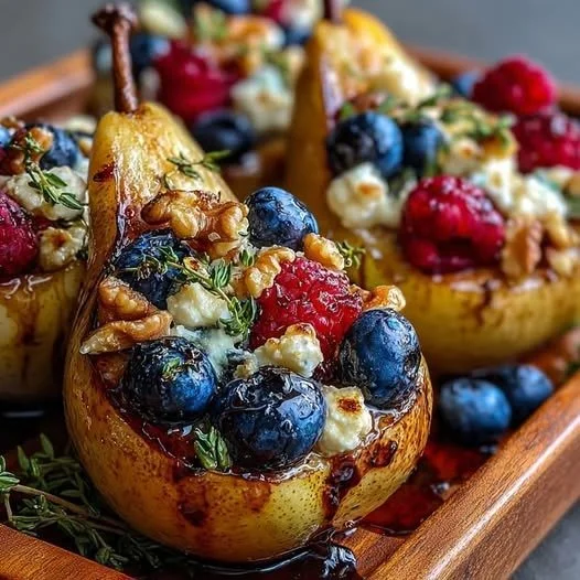 Baked pears topped with berries, honey, walnuts, and blue cheese