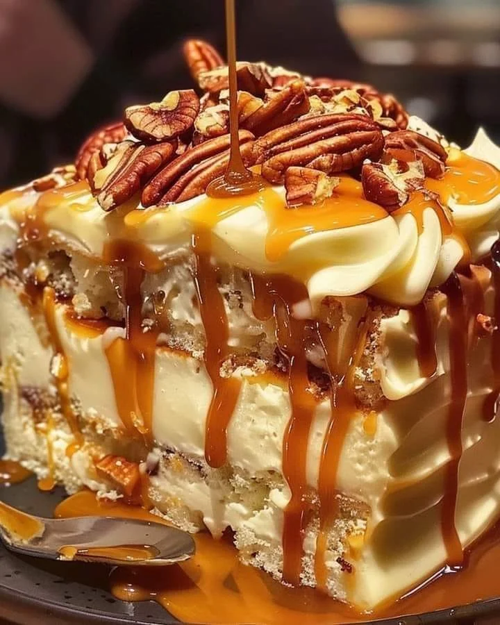 Delicious Butter Pecan Praline Poke Cake topped with pecans and praline sauce.