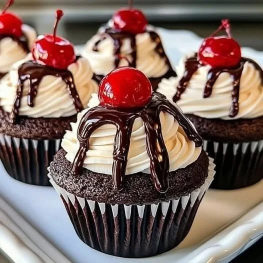 Delicious chocolate cherry cupcakes topped with cherry glaze and chocolate chunks