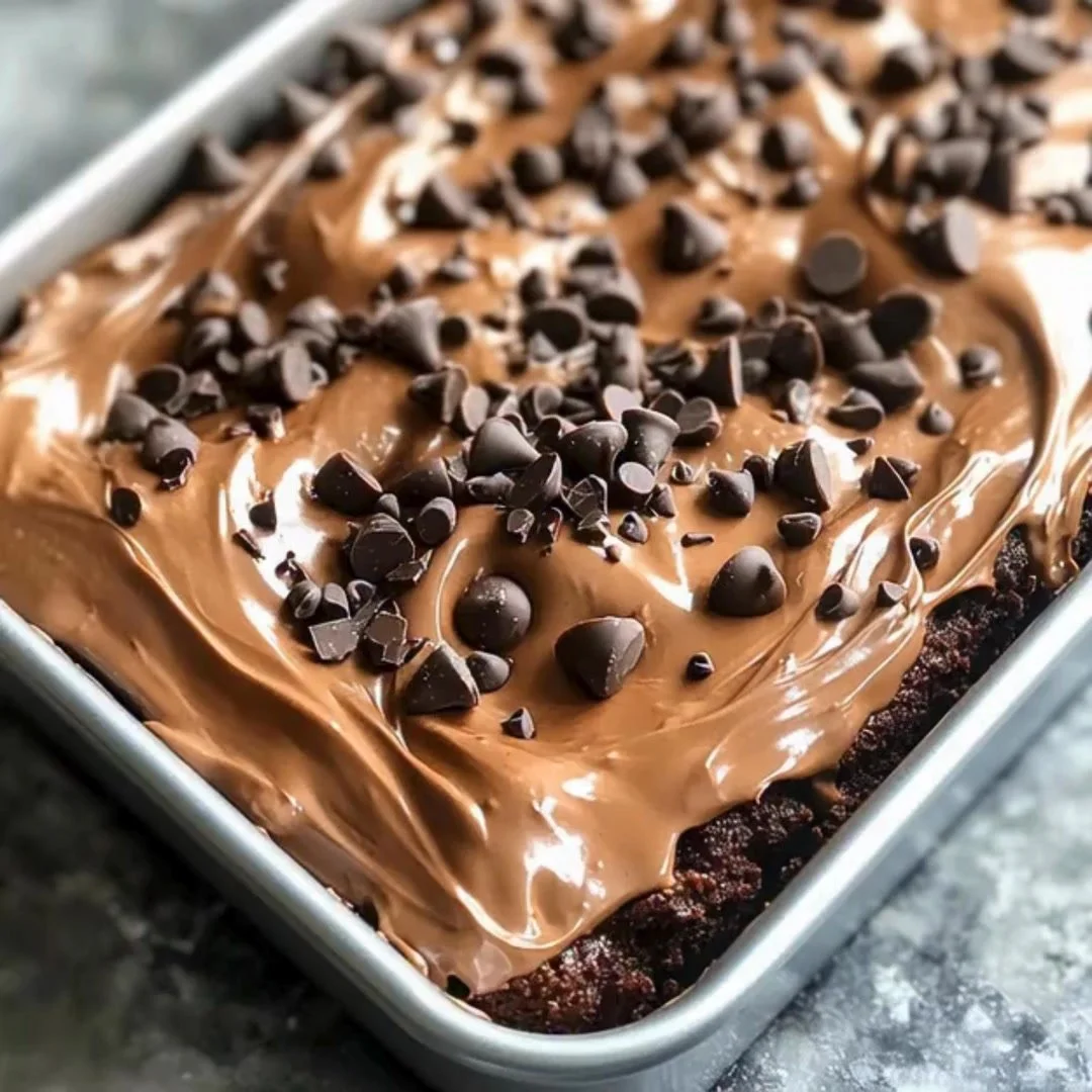 Delicious Death by Chocolate Poke Cake topped with chocolate sauce and whipped cream.