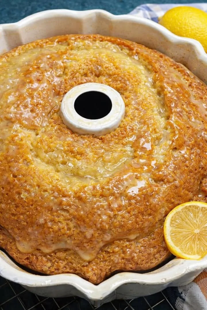 Slice of Easy Lemon 7-Up Cake on a white plate, garnished with lemon slices.