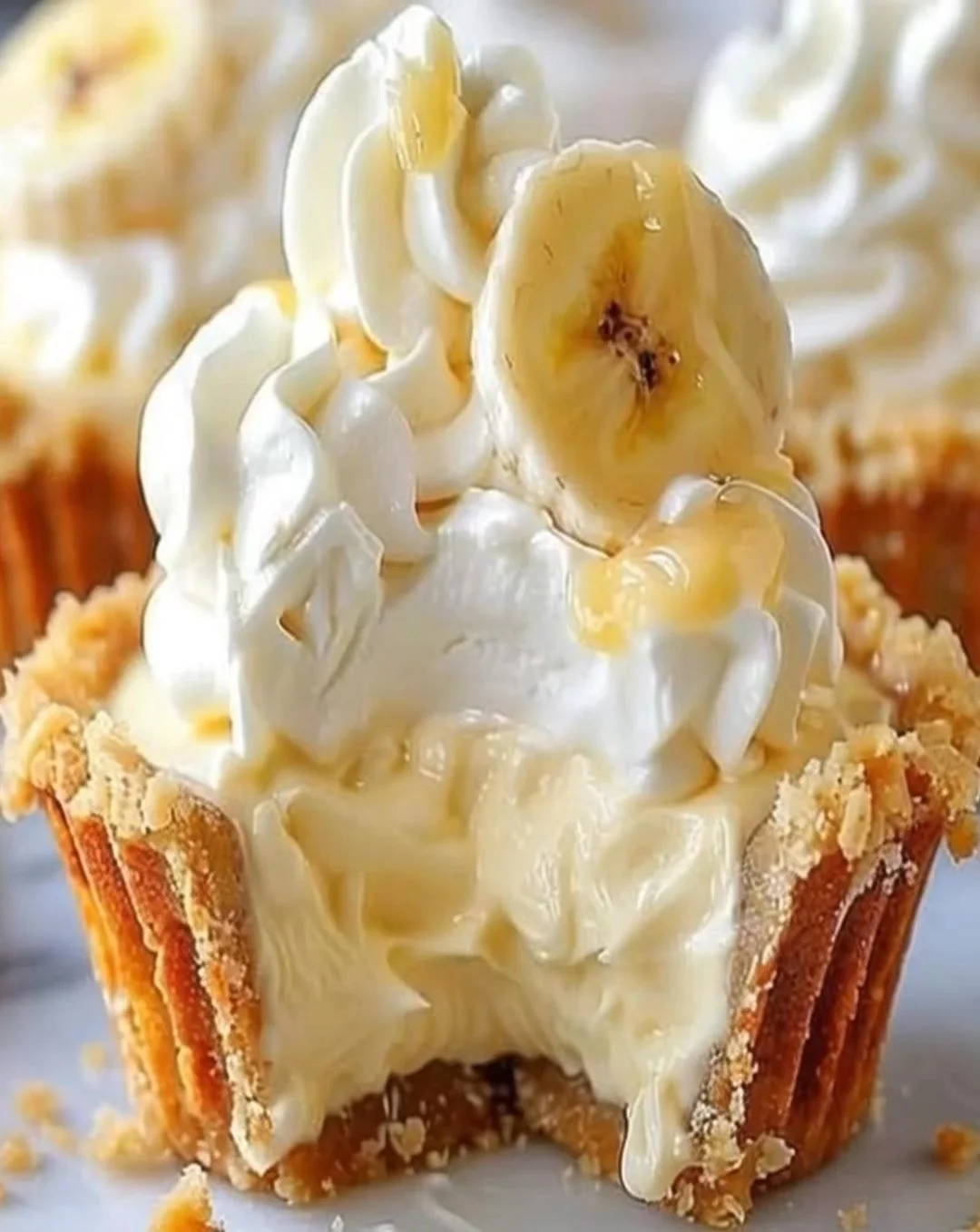 No-bake mini banana cream pies topped with whipped cream and banana slices