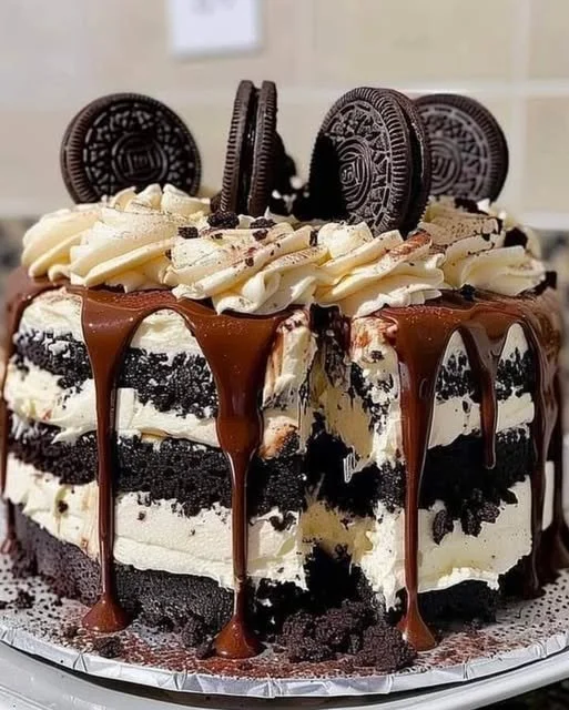 Delicious Oreo cheesecake cake topped with crushed Oreos and cream.