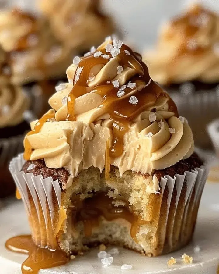 Decadent salted caramel cupcakes with gooey caramel filling on a rustic table