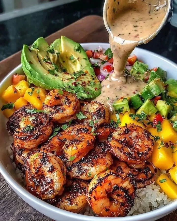 Shrimp avocado bowls with mango salsa and lime-chili sauce served in a bowl