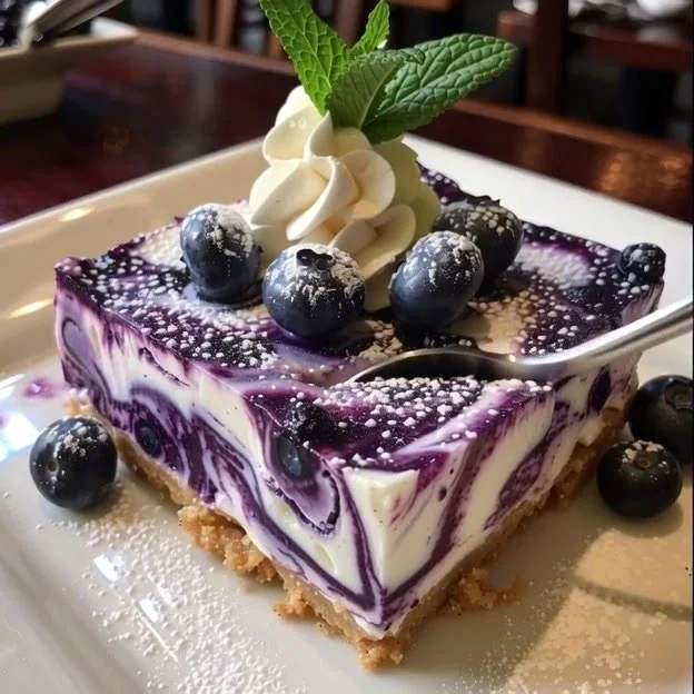 Delicious white chocolate blueberry cheesecake slice with fresh blueberries on top.