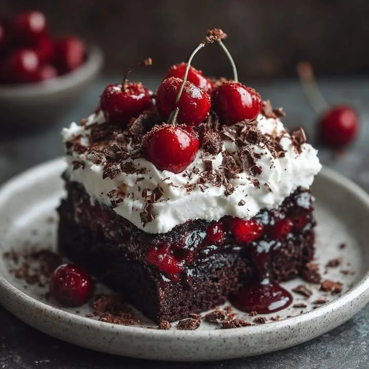 Delicious Black Forest Poke Cake with cherries and whipped cream topping
