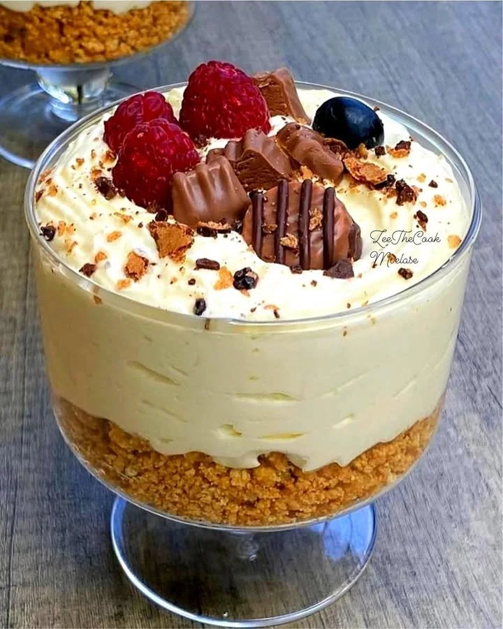 No-bake cheesecake served in a cup, topped with fresh fruit and whipped cream.