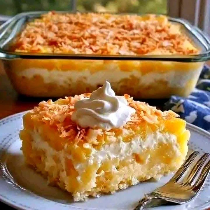 Slice of Pineapple Coconut Dream Cake topped with fresh pineapple and coconut flakes