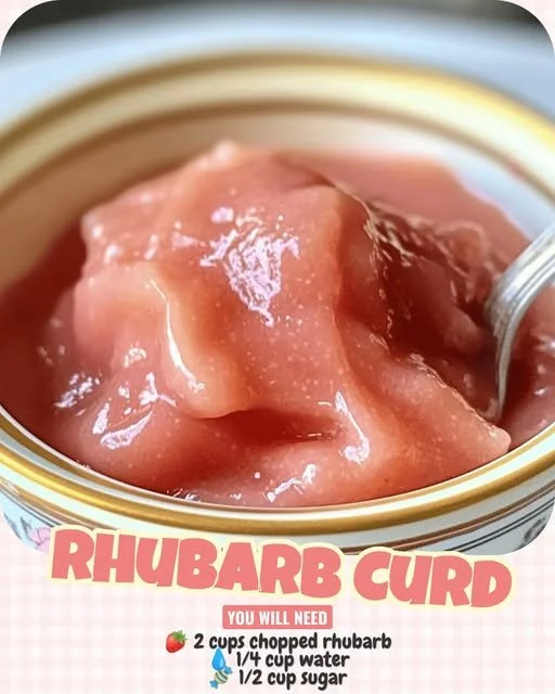 Vibrant jar of homemade rhubarb curd with fresh rhubarb stalks beside it