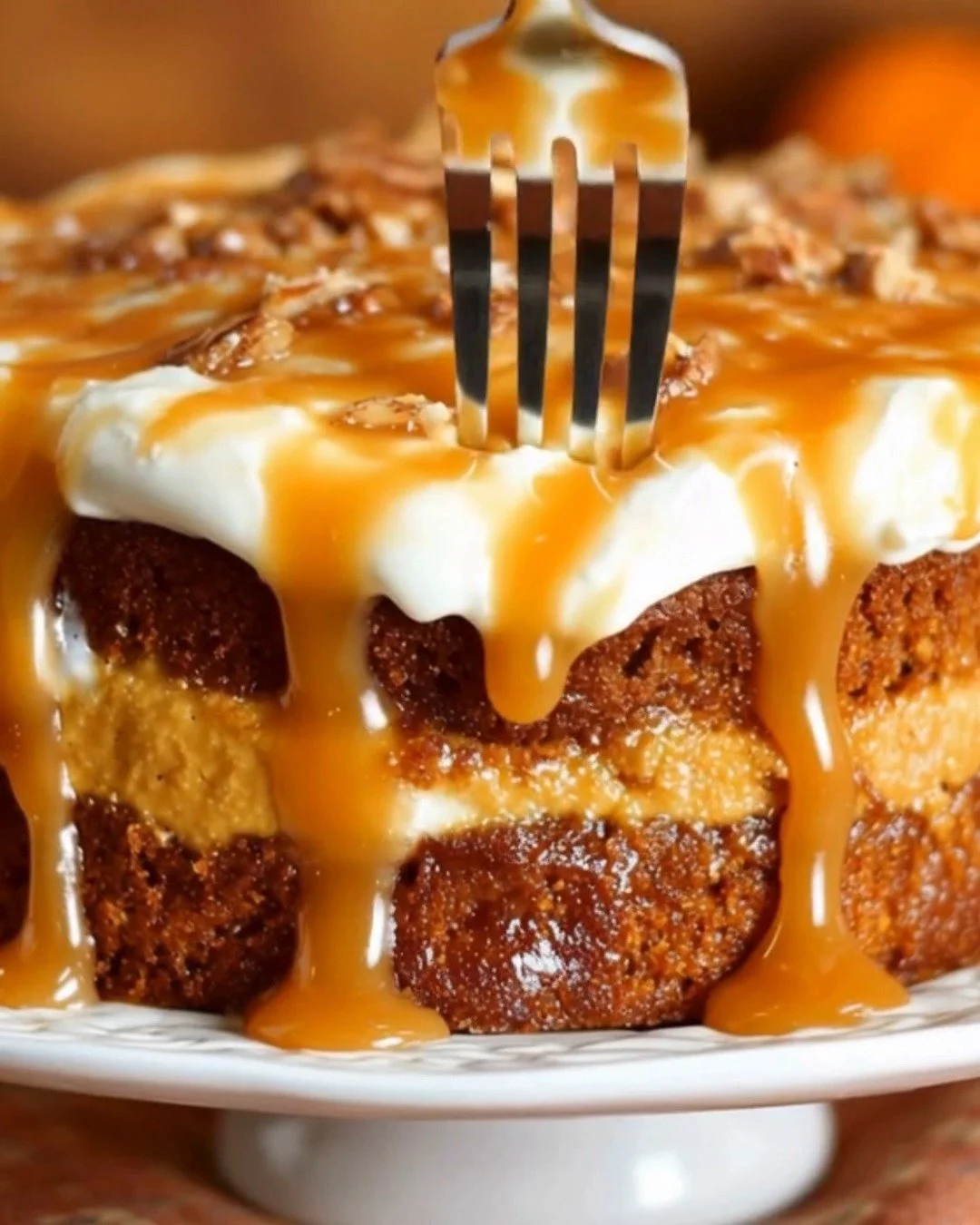 Slice of salted caramel pumpkin cake with toppings served on a plate