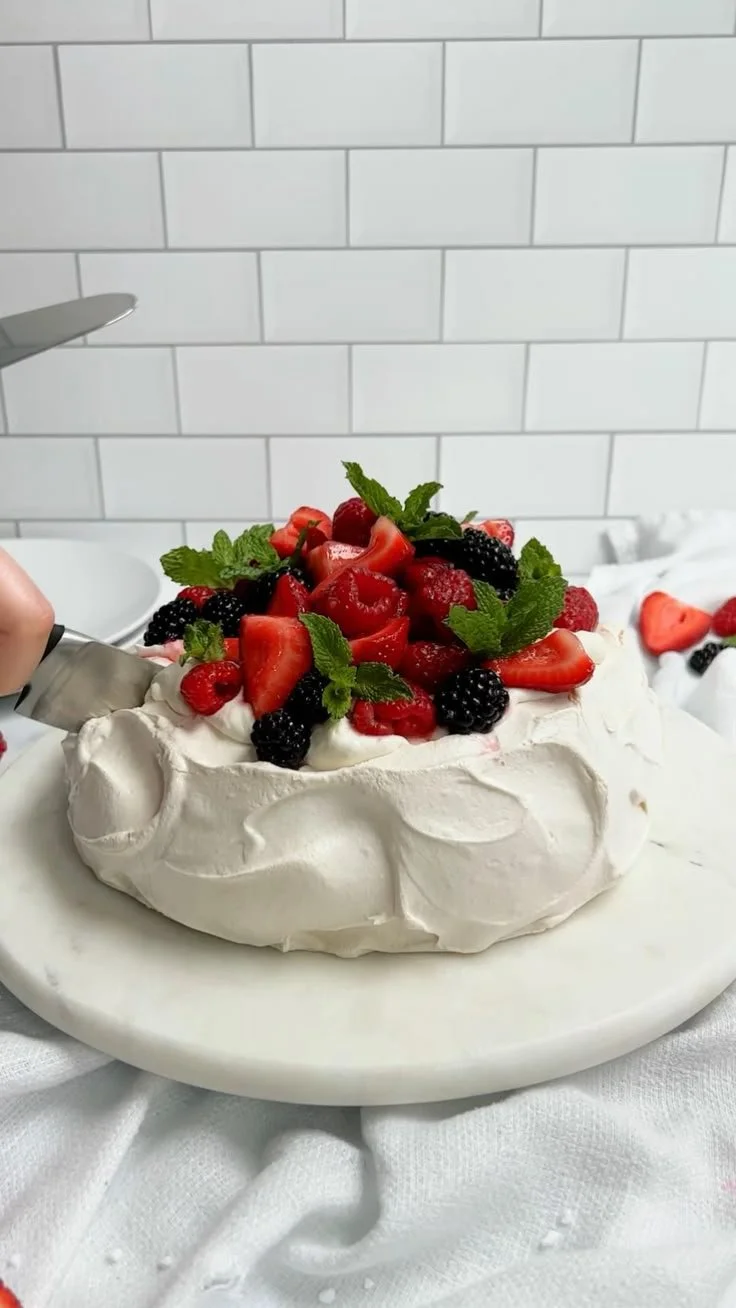 Berry Pavlova dessert topped with fresh berries and whipped cream