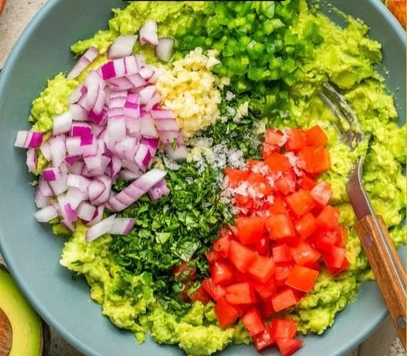Delicious homemade guacamole served in a bowl with fresh ingredients