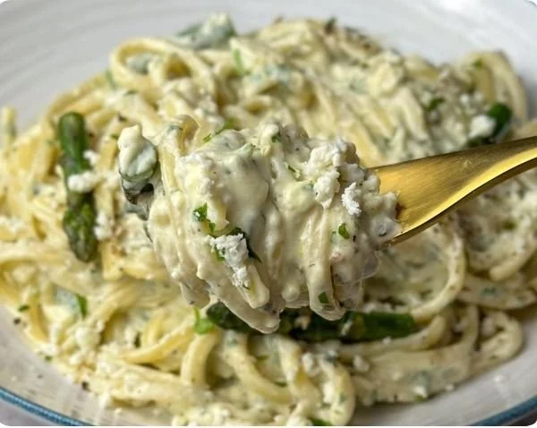 Creamy lemon feta pasta garnished with fresh herbs and lemon zest.
