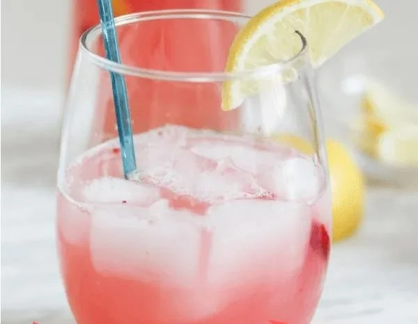 Glass of homemade rhubarb lemonade garnished with fresh rhubarb and lemon slices