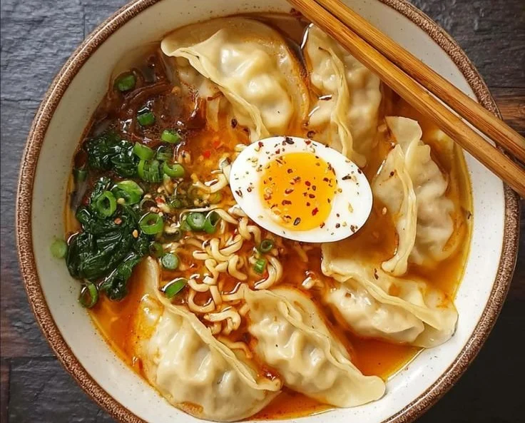 Bowl of Dumpling Ramen with fresh herbs and vegetables