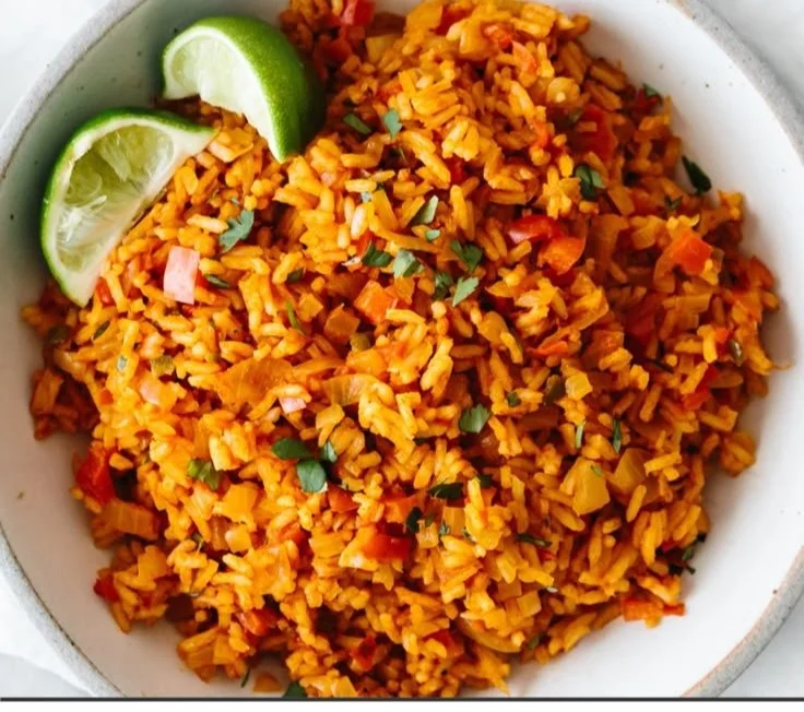 Plate of easy Mexican rice garnished with cilantro and lime wedges