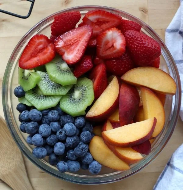 Colorful fruit salad with honey lime dressing in a bowl
