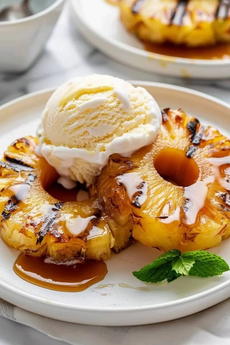 Sliced grilled pineapple served on a plate, a delicious tropical dessert