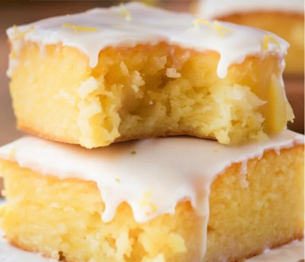 Zesty lemon brownies, also known as lemonies, on a white plate