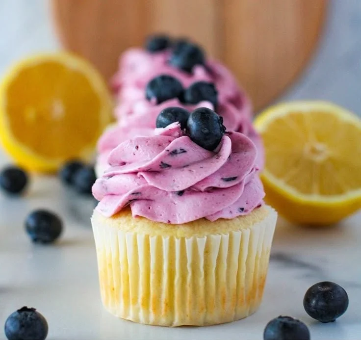 Lemon cupcakes with blueberry buttercream on a decorative plate
