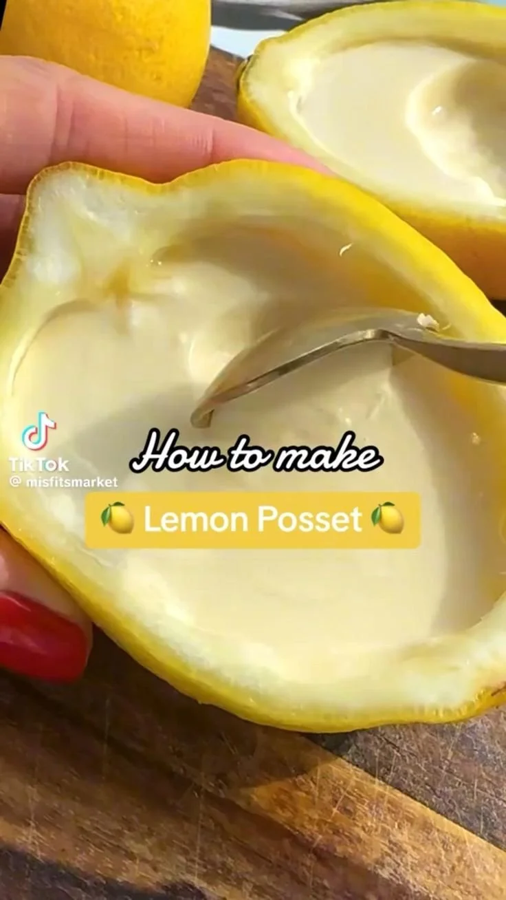 Creamy lemon posset dessert topped with lemon zest and served in a glass bowl.