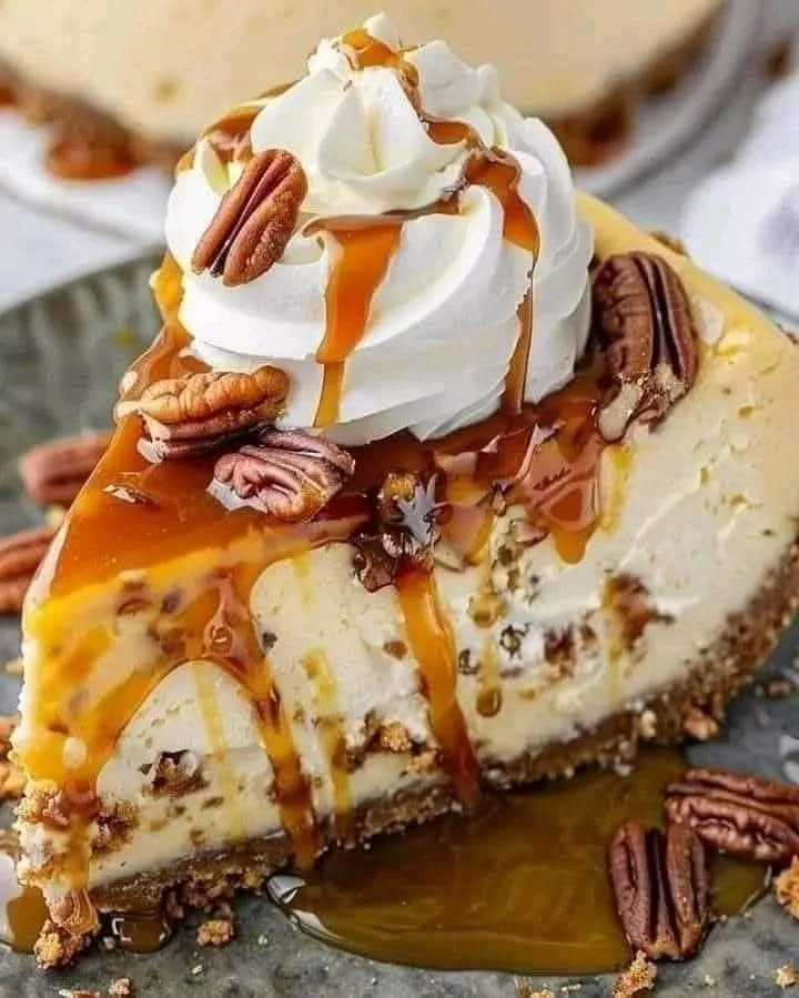 Luxurious caramel pecan cheesecake topped with nuts and caramel sauce