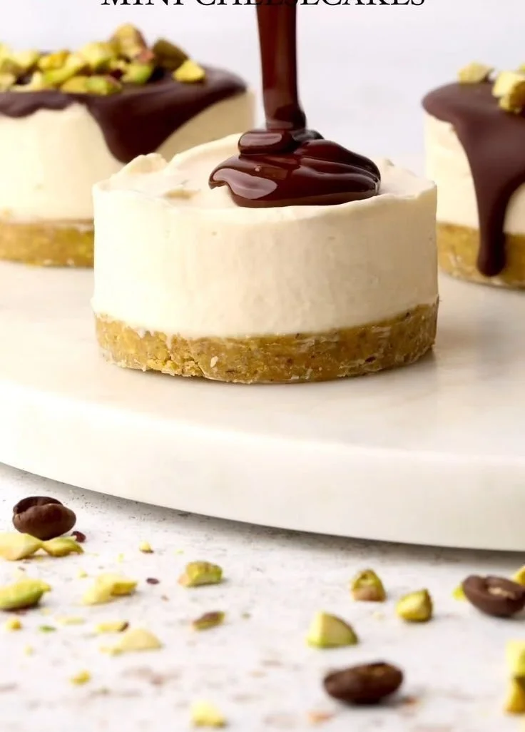 Mini pistachio and coffee cheesecakes topped with crushed pistachios.