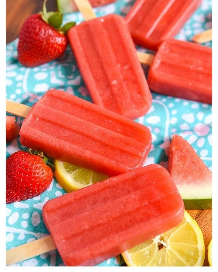 Nutritious strawberry watermelon popsicles on a wooden table