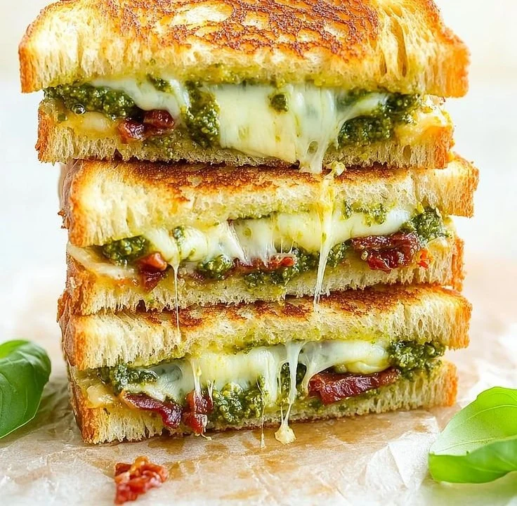 Delicious pesto grilled cheese sandwich with melted cheese and fresh basil.