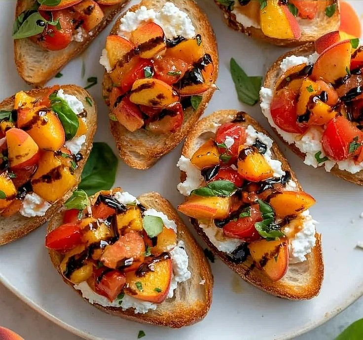 Simple peach bruschetta topped with whipped ricotta on a rustic wooden board