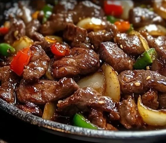 Sizzling Chinese pepper steak with onions served on a plate