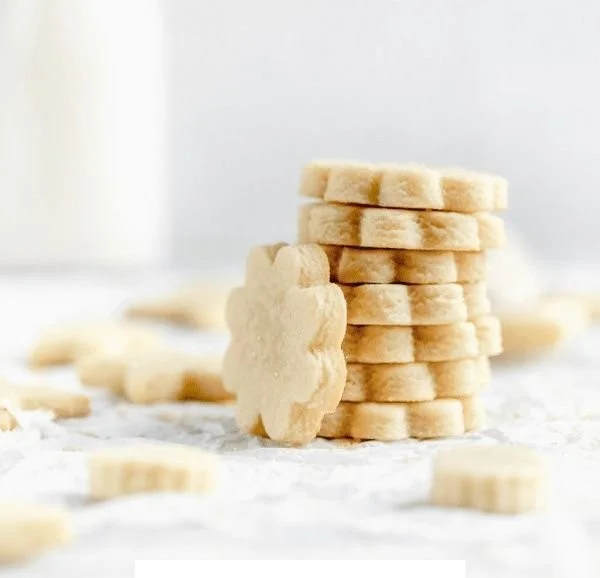 Plate of freshly baked sugar cookies decorated with frosting and sprinkles
